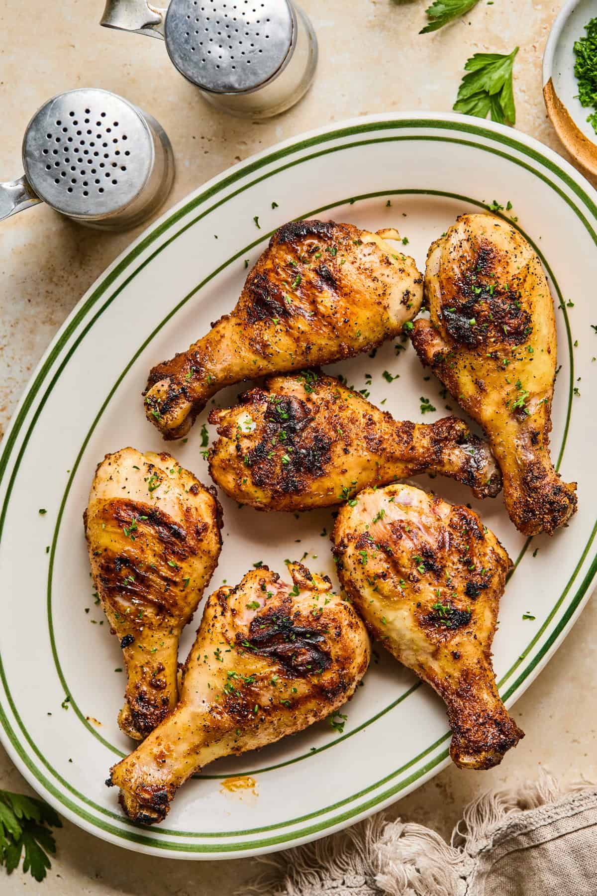 Grilled chicken legs resting on plate.