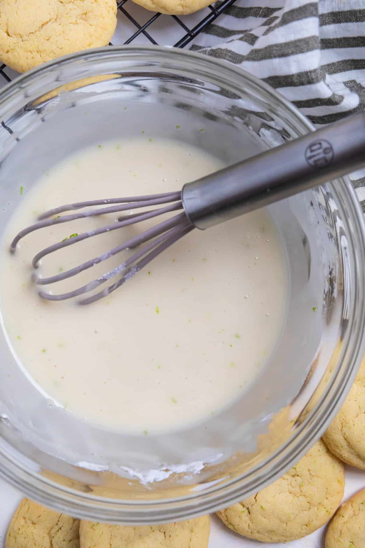 Lime icing for cookies in mixing bowl with whisk.
