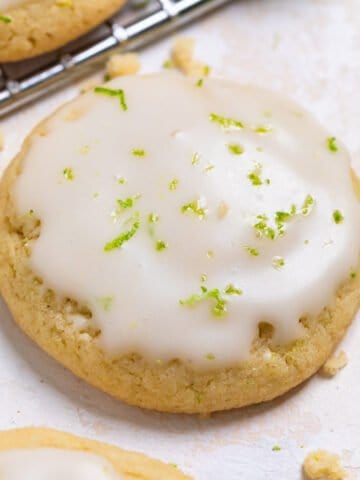 Key lime cookie with lime glaze and zest on counter.