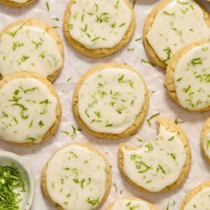 Key lime cookies with lime glaze and zest on surface.