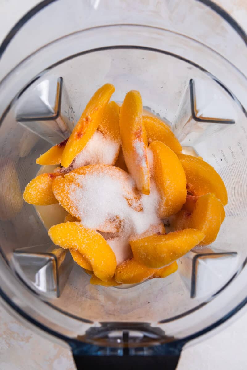Peaches, sugar and other peach popsicle ingredients in blender.