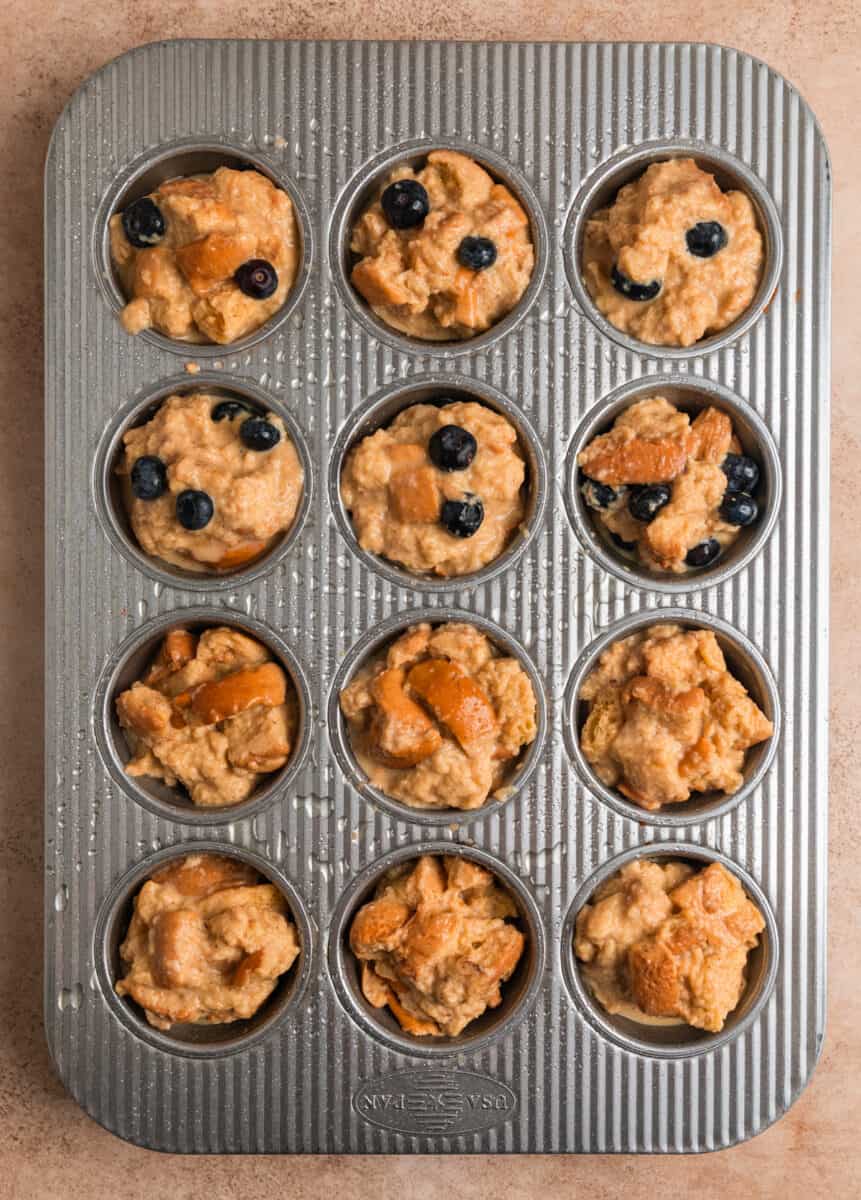 Muffin tin with French toast muffin mixture and blueberry French toast muffin mixture.