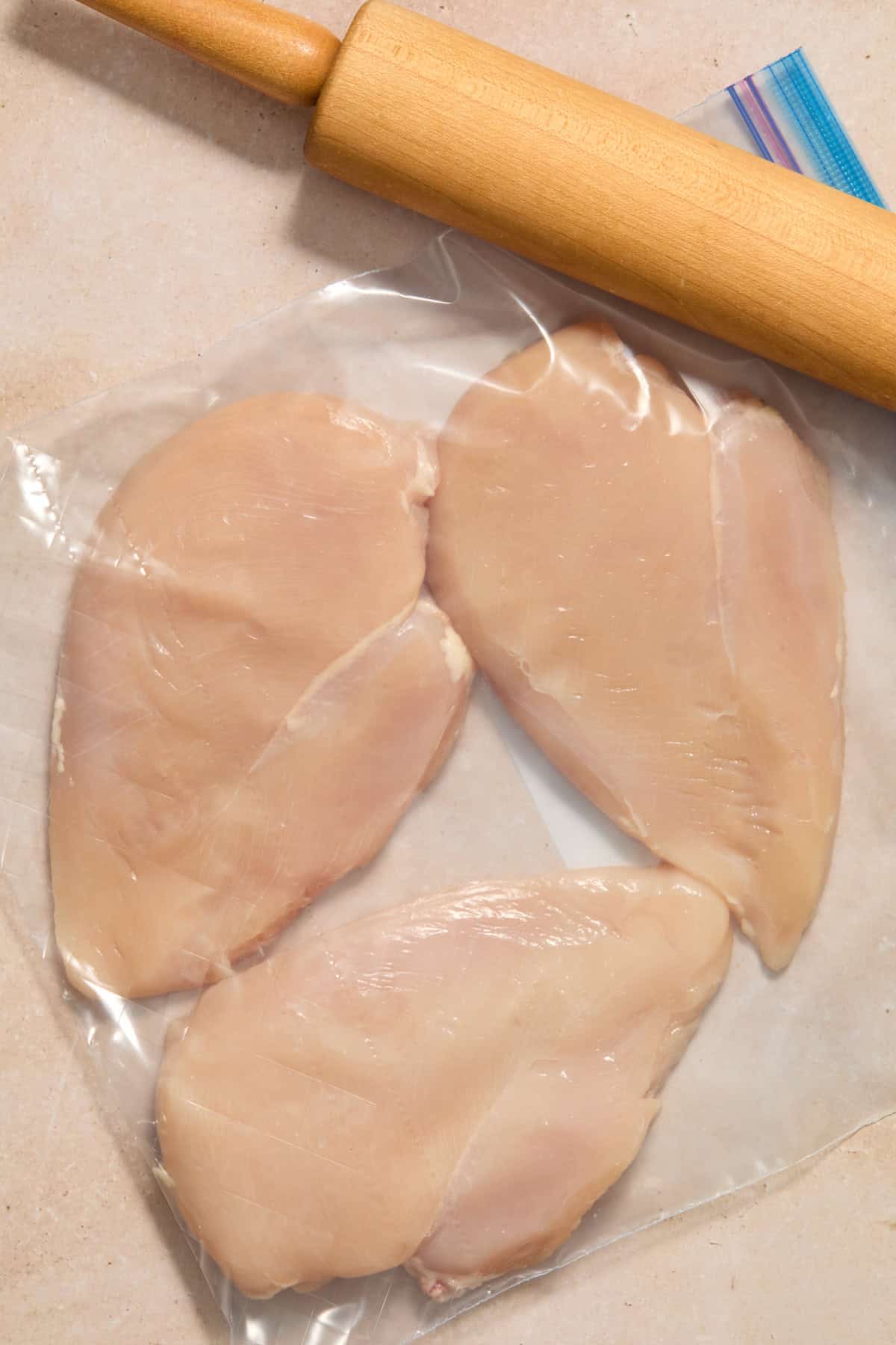 Chicken pounded in plastic bag with rolling pin.
