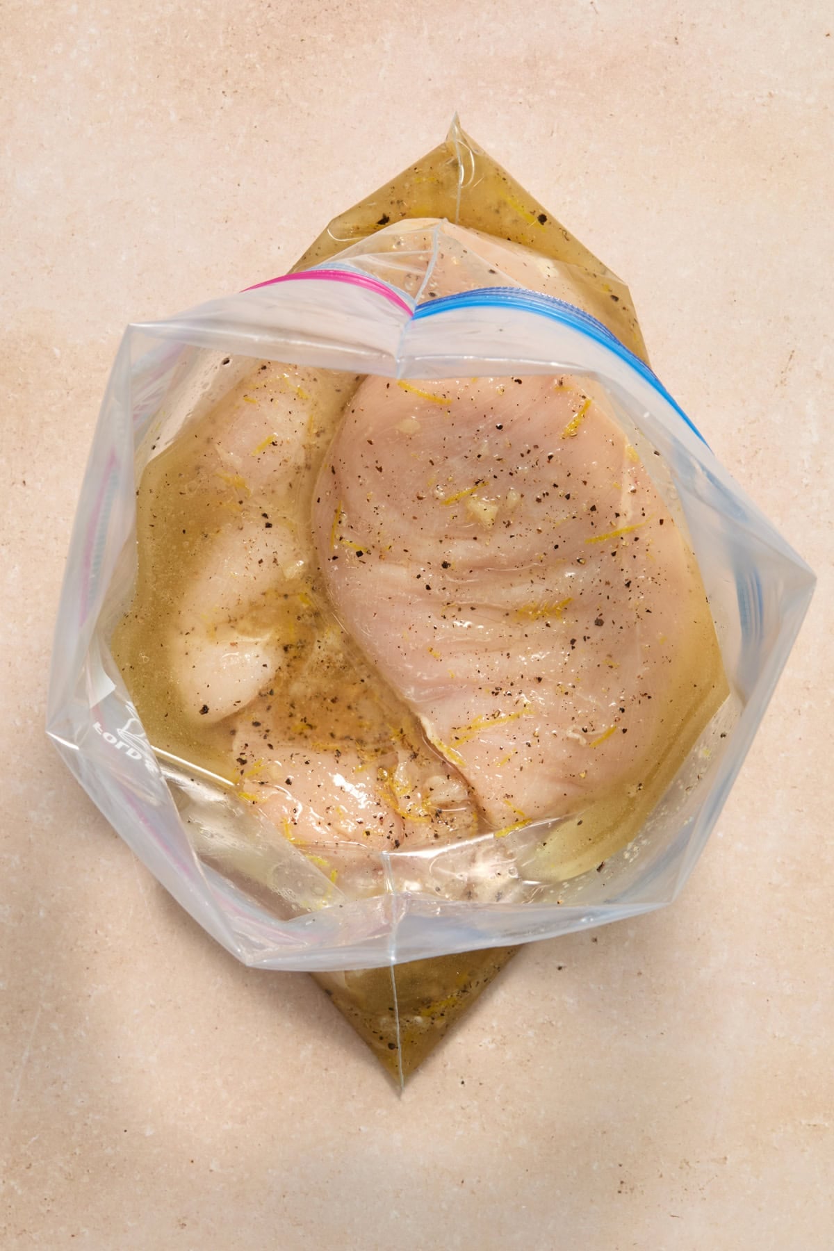 Lemon pepper marinade added to bag with chicken breasts.