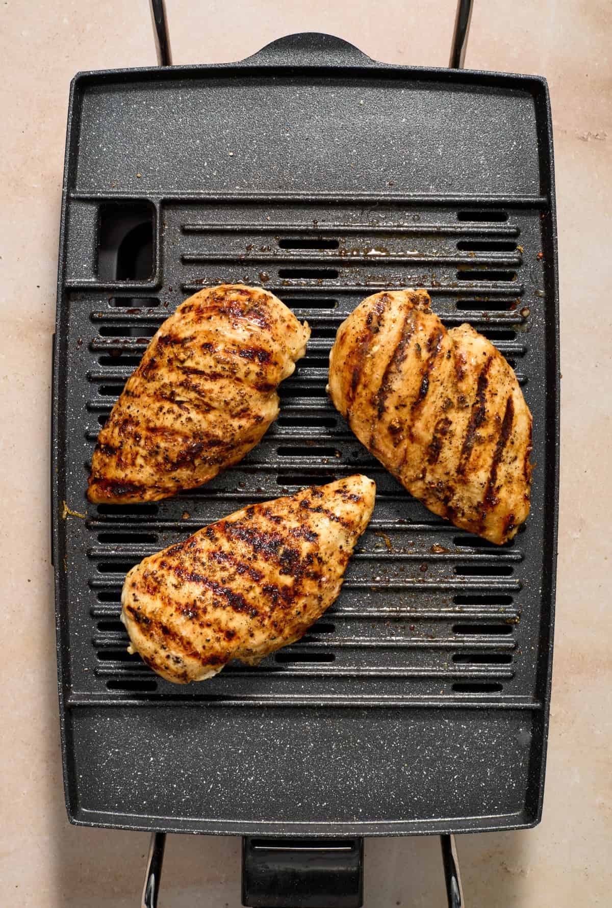Indoor grill with lemon pepper chicken grilling.