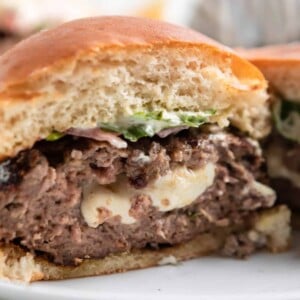 Mozzarella stuffed burger sliced in half with cheese inside.