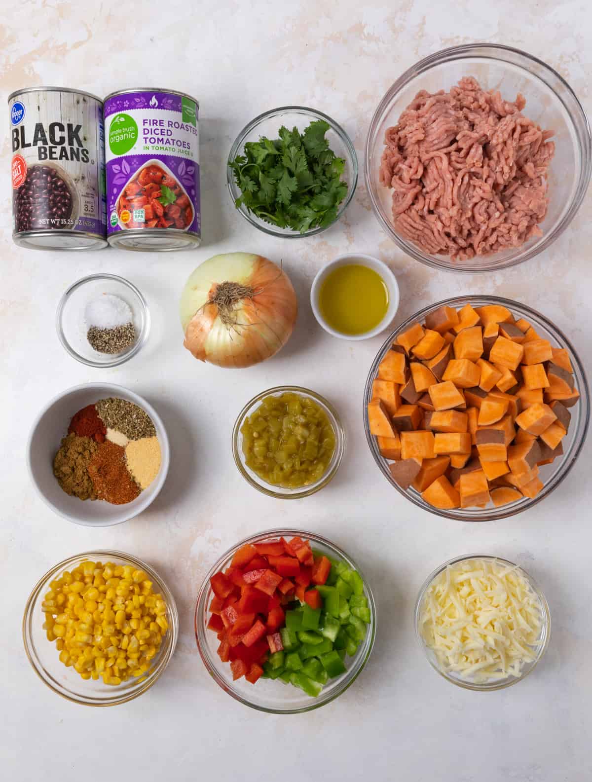 Ground turkey, beans, tomatoes, bell pepper and other recipe ingredients on counter.
