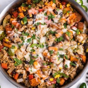 Ground turkey sweet potato skillet dinner in pan with shredded cheese melted on top.