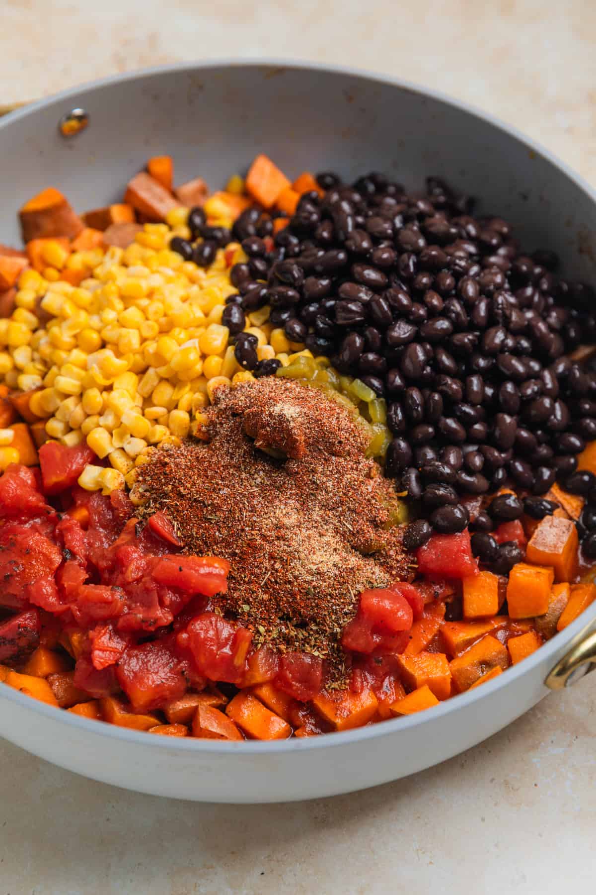 Black beans, corn, tomatoes and seasoning added to skillet with cooked sweet potatoes.