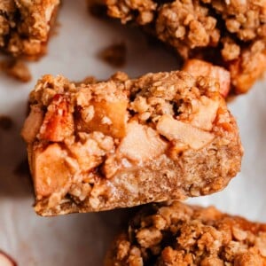 Apple crumble bar propped on surrounding sliced bars.