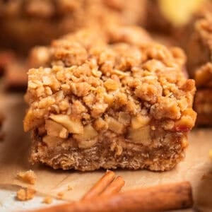 Apple crumble oat bar on parchment showing layers of apple and oat base.