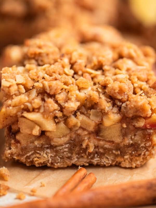 Apple crumble oat bar on parchment showing layers of apple and oat base.