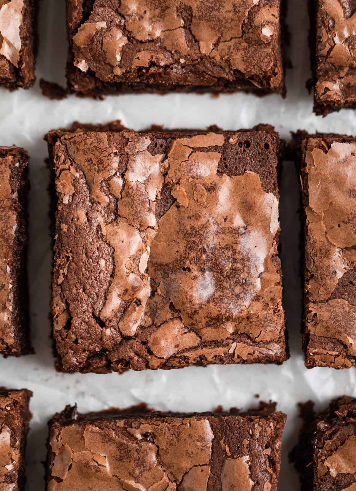 Condensed brownies sliced and lined up on parchment.
