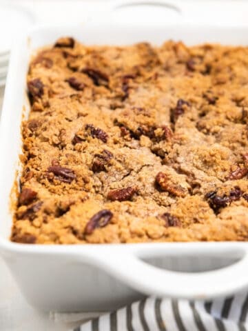 White casserole dish with pumpkin spice French toast baked with pecan streusel topping.