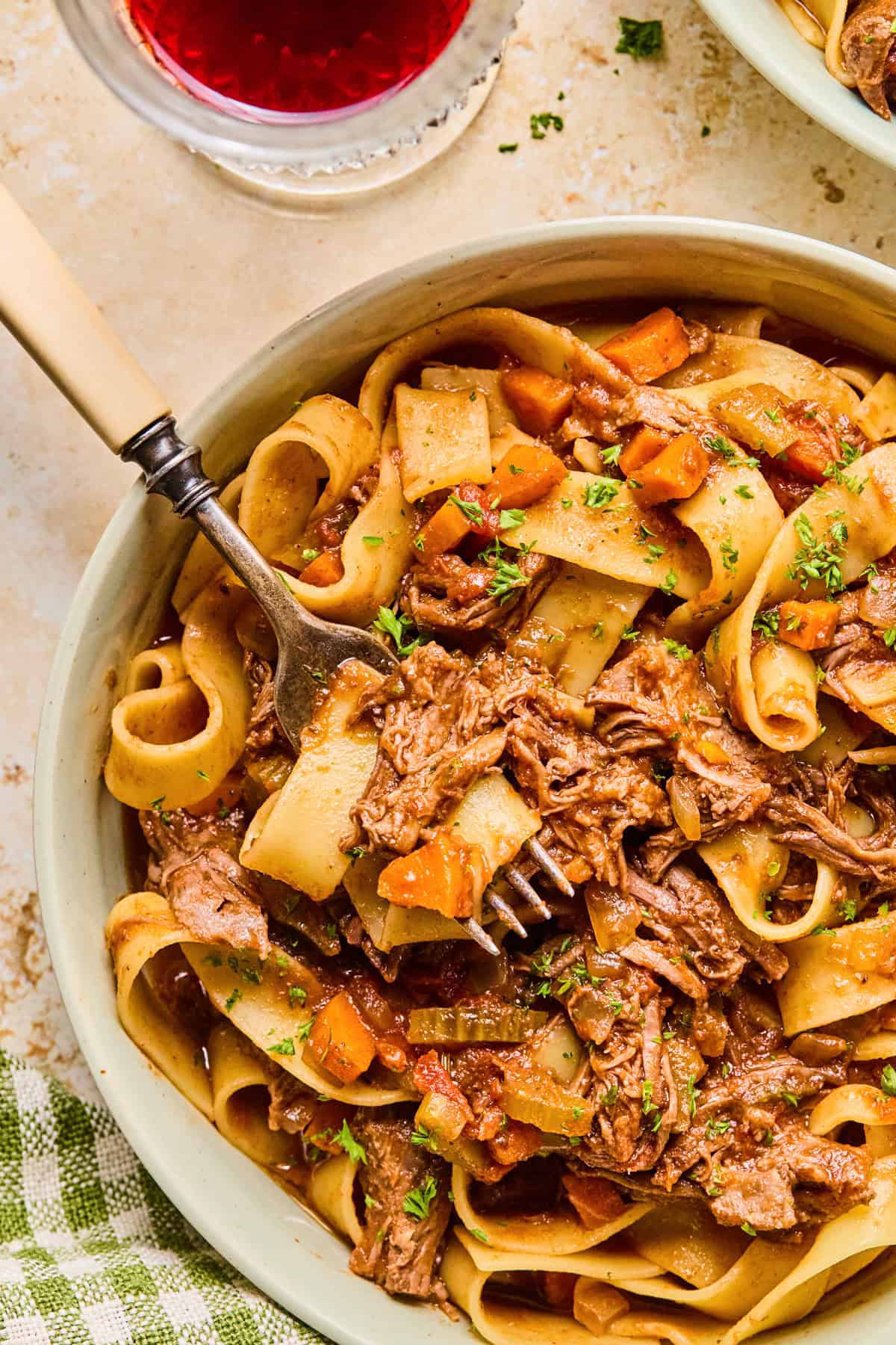 Bowl with slow cooker short rib ragu and fork scooping in.