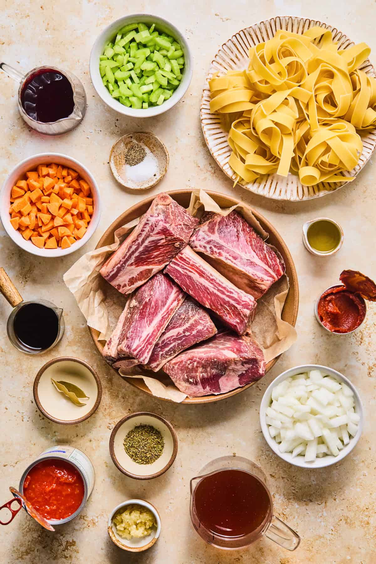 Meat, vegetables, pasta and seasoning arranged on surface to make recipe.