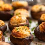 Stuffed air fryer mushrooms on white plate topped with finely chopped fresh parsley.