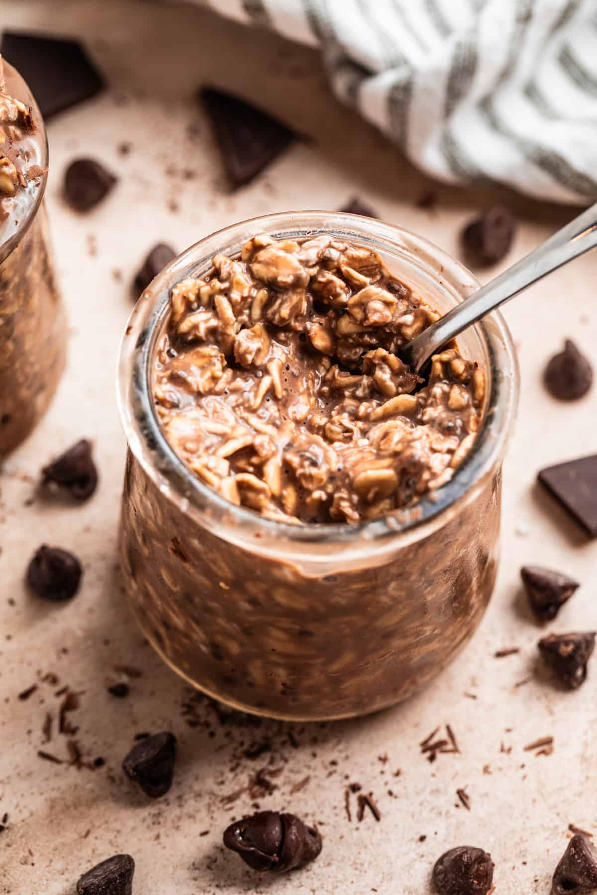 Spoon scooping into jar with chocolate overnight oats.