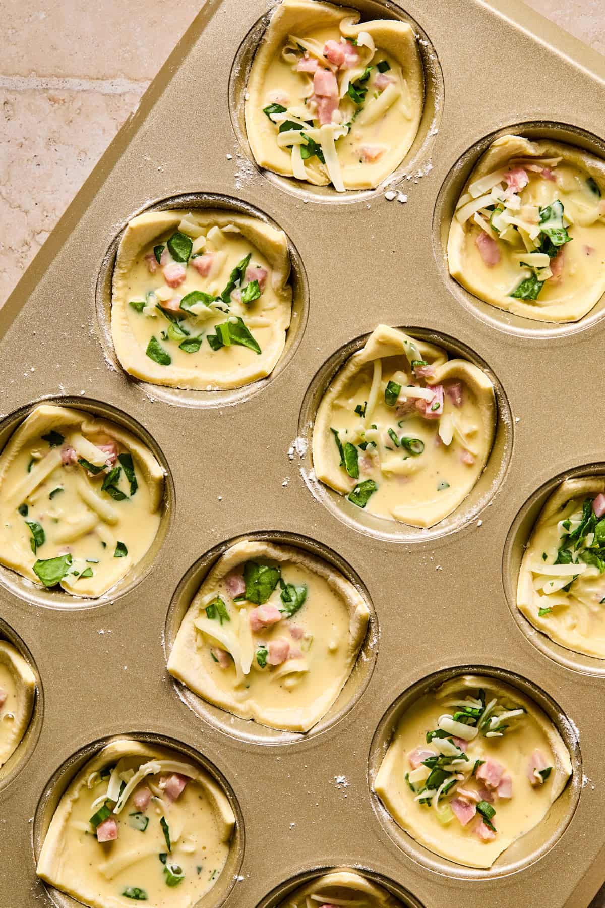 Egg filled puff pastry cups in muffin tin.