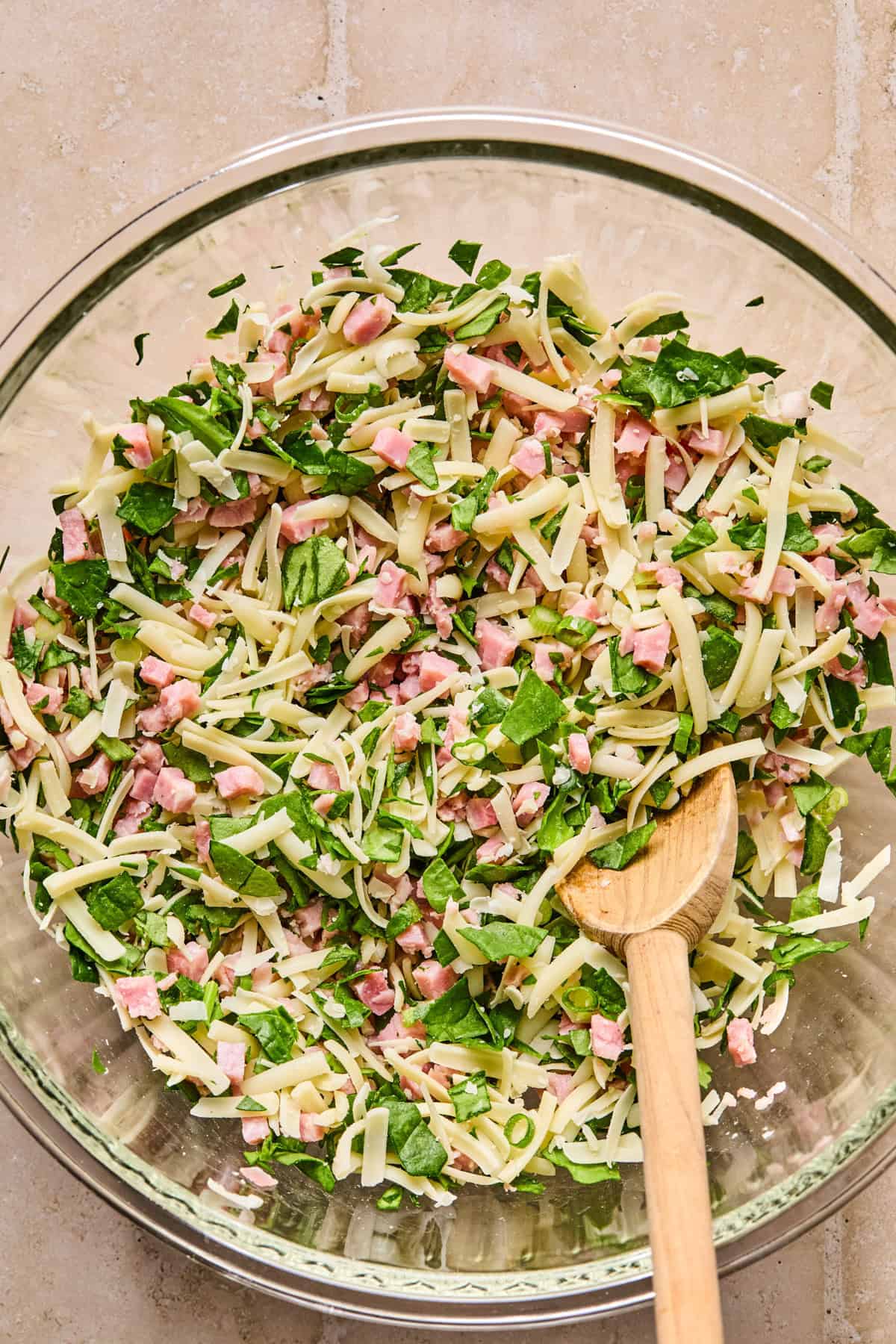 Ham, cheese and spinach combined in mixing bowl.