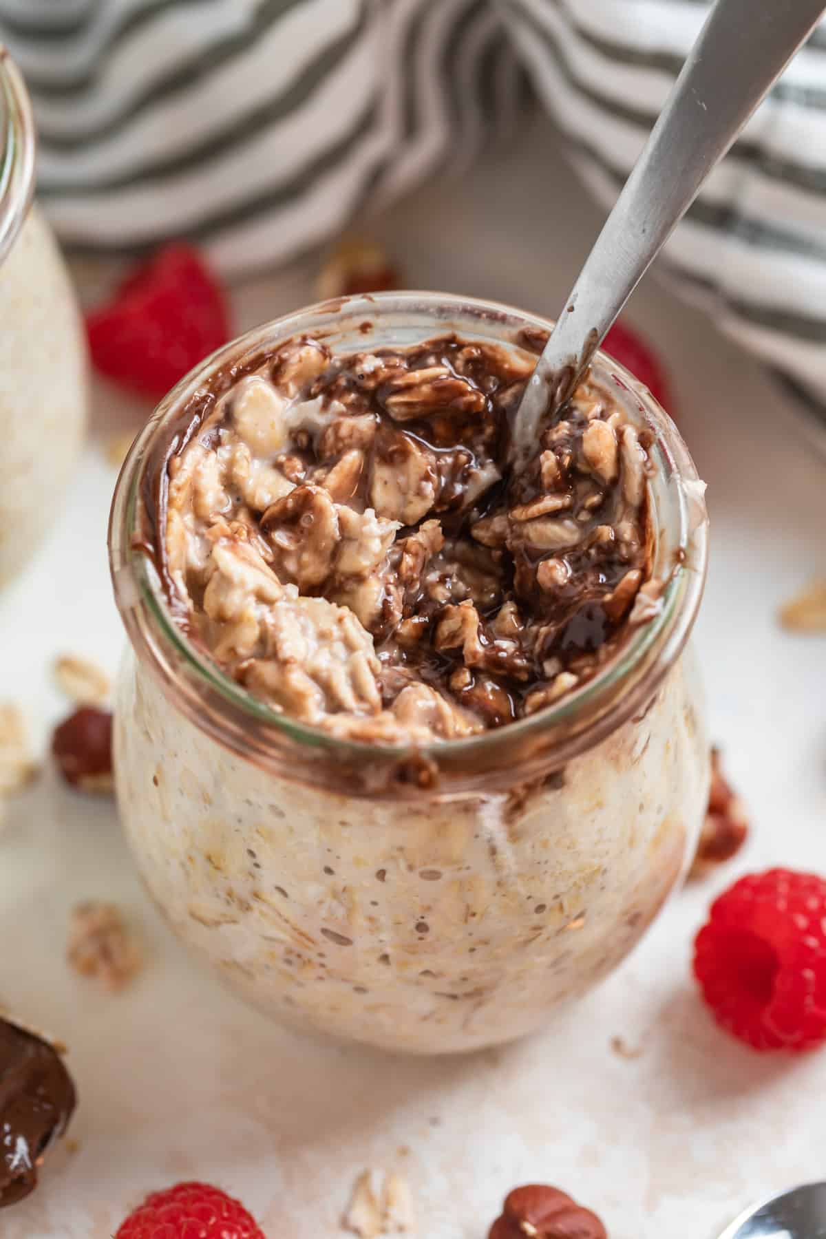 Nutella overnight oats in jar with spoon scooped into it.