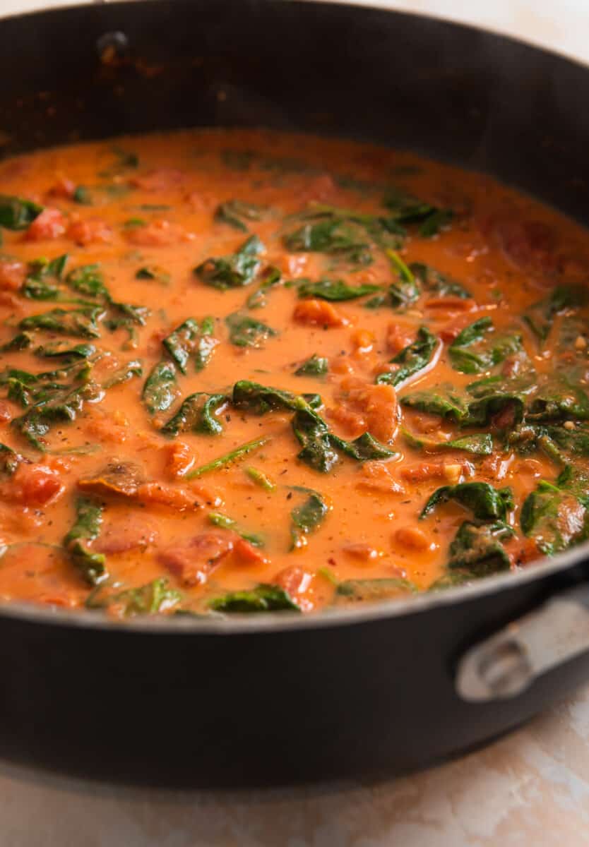Spinach wilted in creamy tomato parmesan sauce.