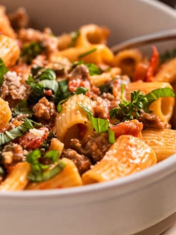 Italian sausage pasta in dish with fork.