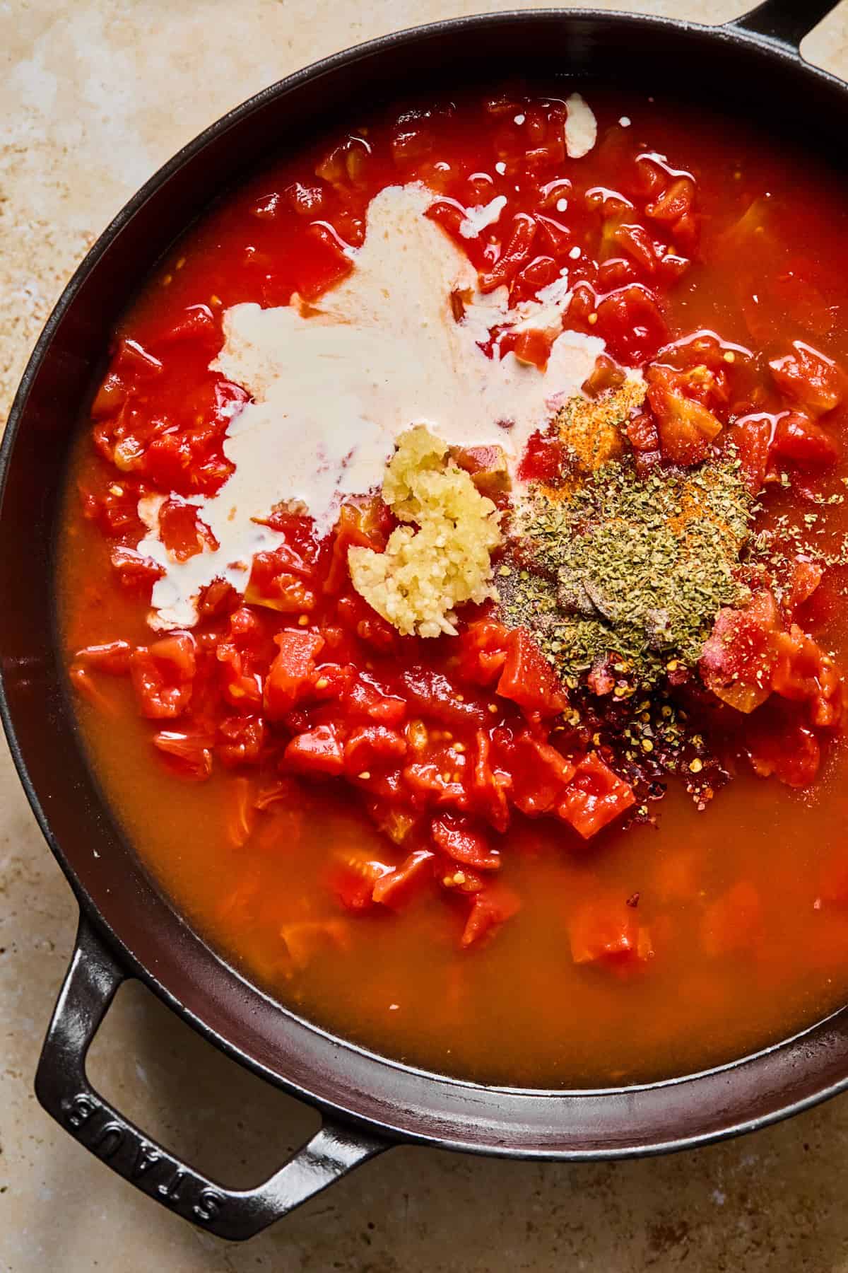Tomatoes, seasoning, cream and other ingredients in skillet.