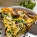 Mushroom Swiss and hamburger quiche slice on white plate with fork.