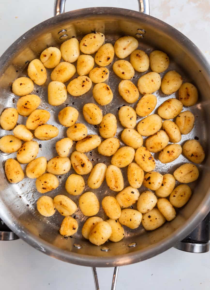 Cooked gnocchi in stainless steel pan.