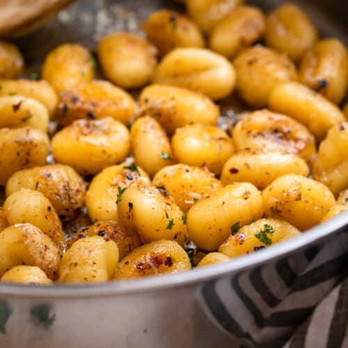 Pan fried gnocchi tossed in butter and parmesan and topped with chopped parsley.