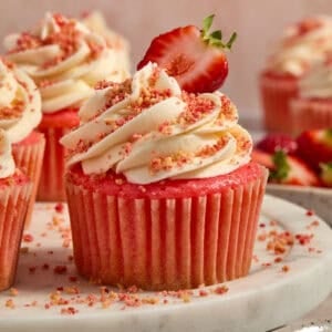 Strawberry cupcakes with buttercream topped strawberry crunch topping.