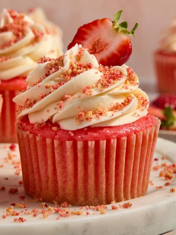 Strawberry cupcakes with buttercream topped strawberry crunch topping.