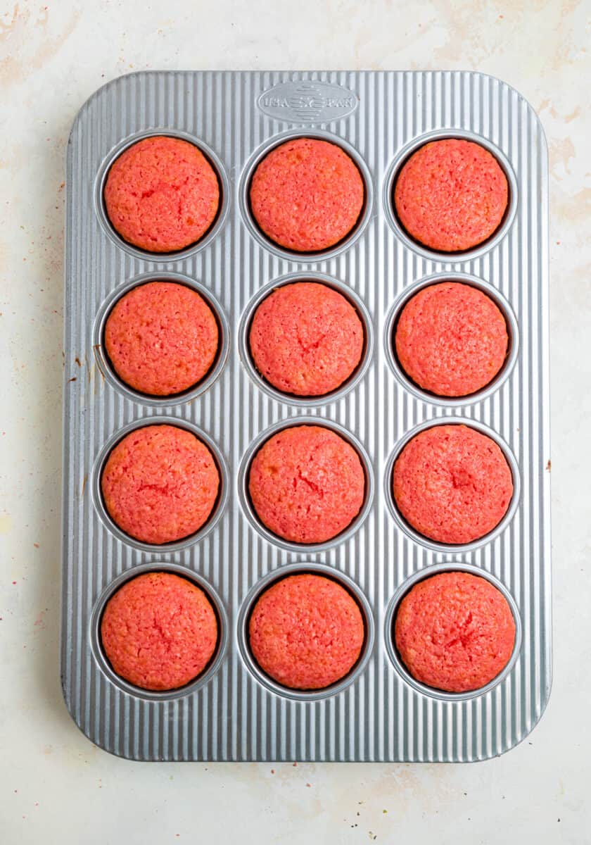 Baked strawberry cupcakes in muffin tin.