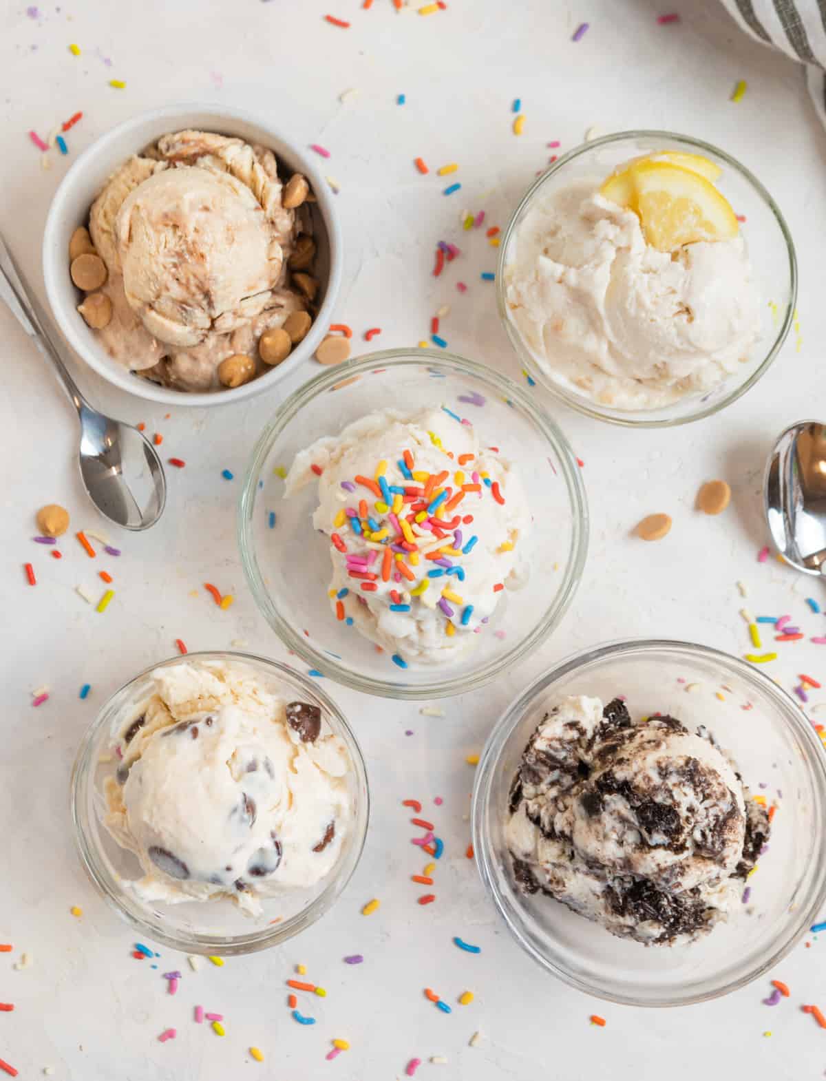 5 ice cream scoops in glasses with toppings.