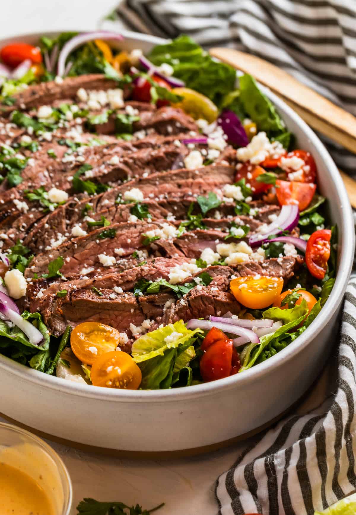 Grilled flank steak salad topped with chopped cilantro and cheese.
