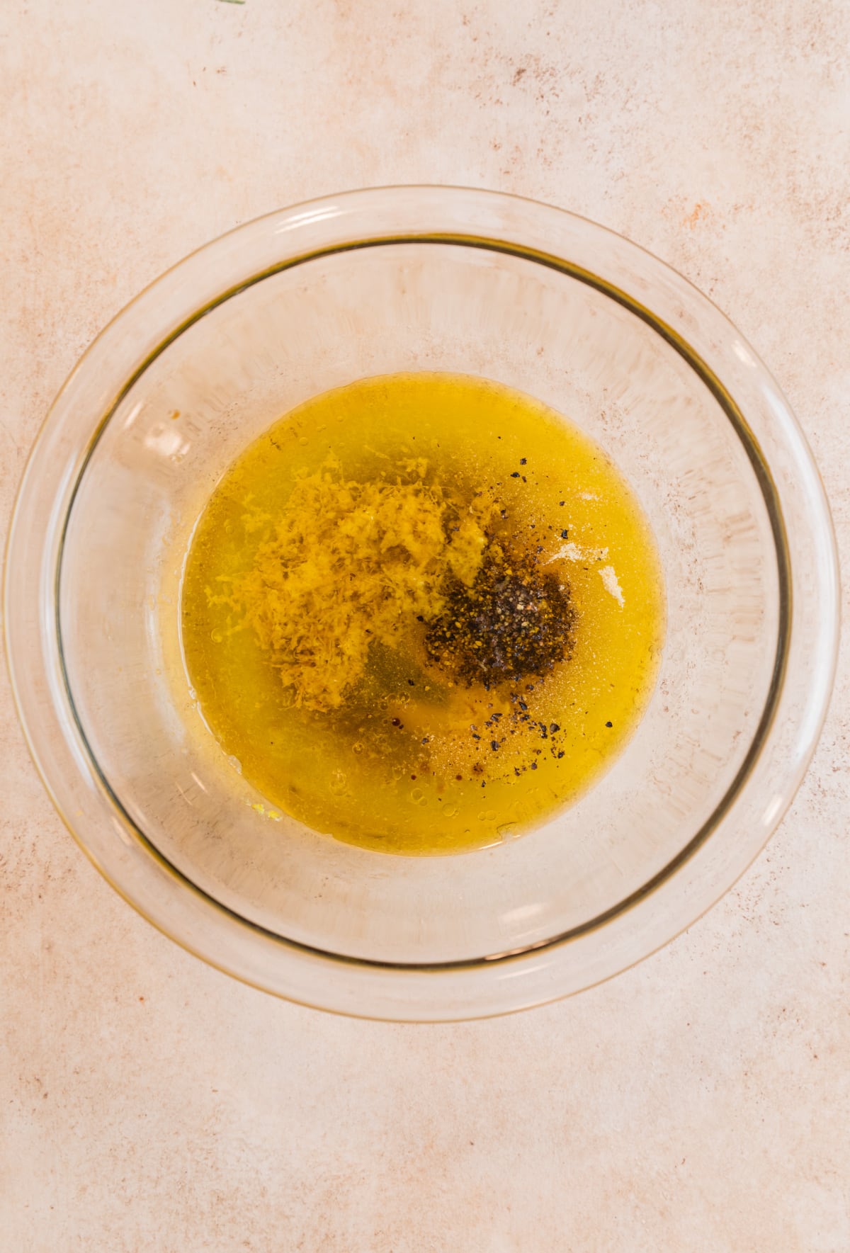Lemon pepper marinade ingredients in glass mixing bowl.