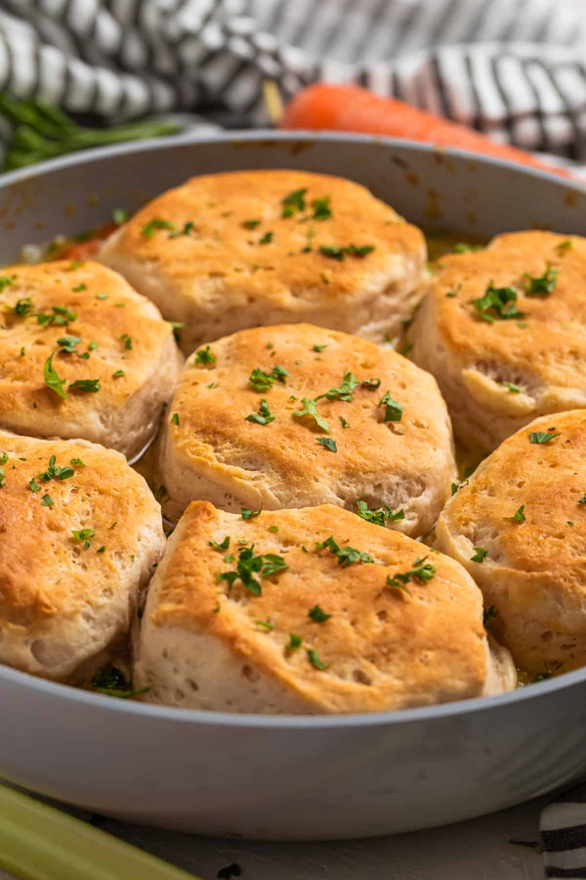 Chicken and biscuits in skillet topped with freshly chopped parsley.