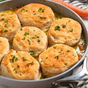 Skillet with cream of chicken and biscuits topped with chopped fresh parsley.