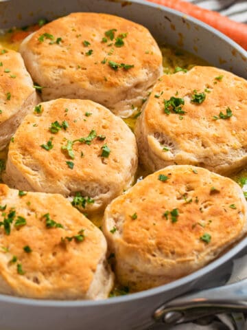Skillet with cream of chicken and biscuits topped with chopped fresh parsley.