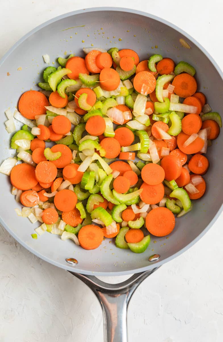 Carrots, celery and onions sautéed in skillet.