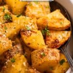 Parmesan crusted potatoes in white bowl with chopped fresh parsley and parmesan over top.