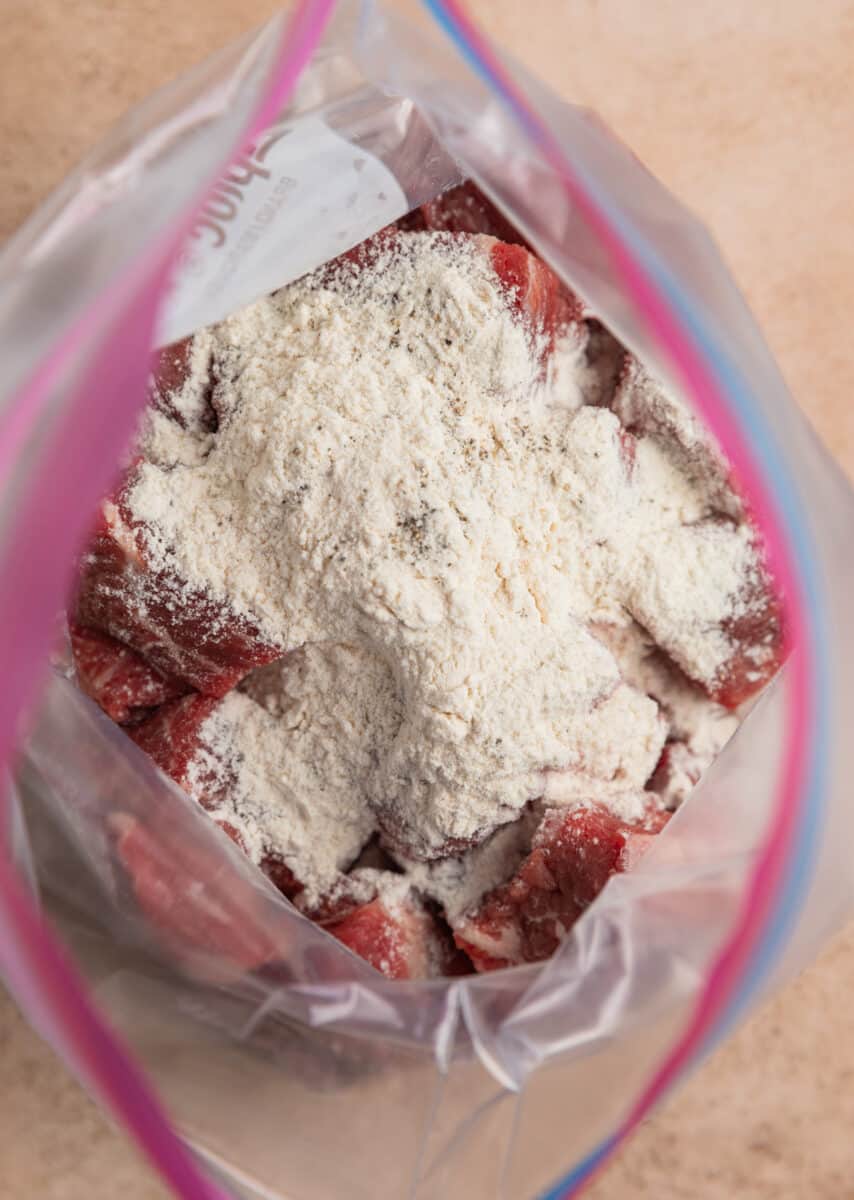 Flour mixture on cubed chuck roast stew meat in plastic bag.