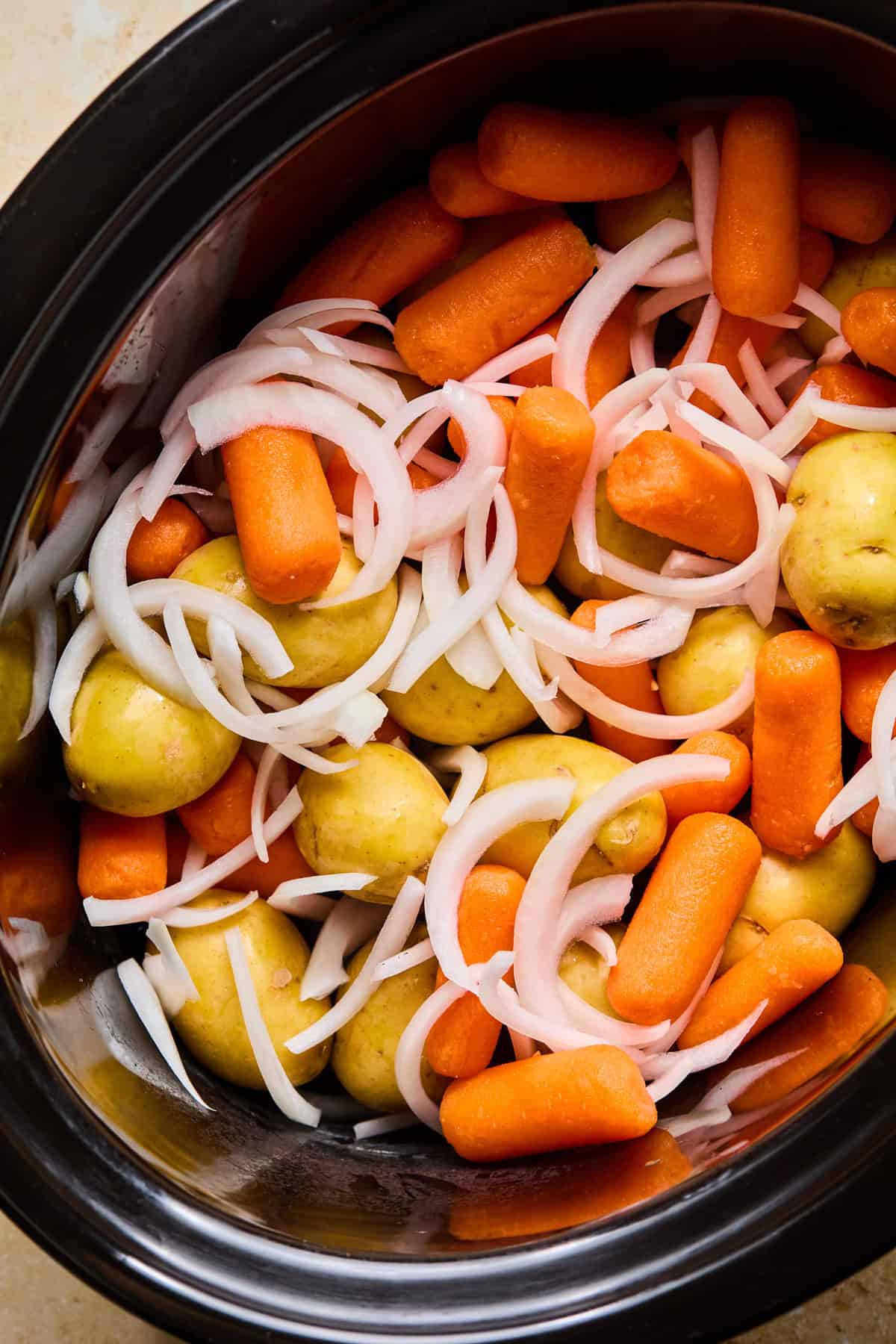 Carrots, onions and potatoes in crock pot.