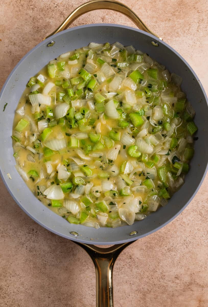 Skillet with butter, onion, celery and herb mixture.