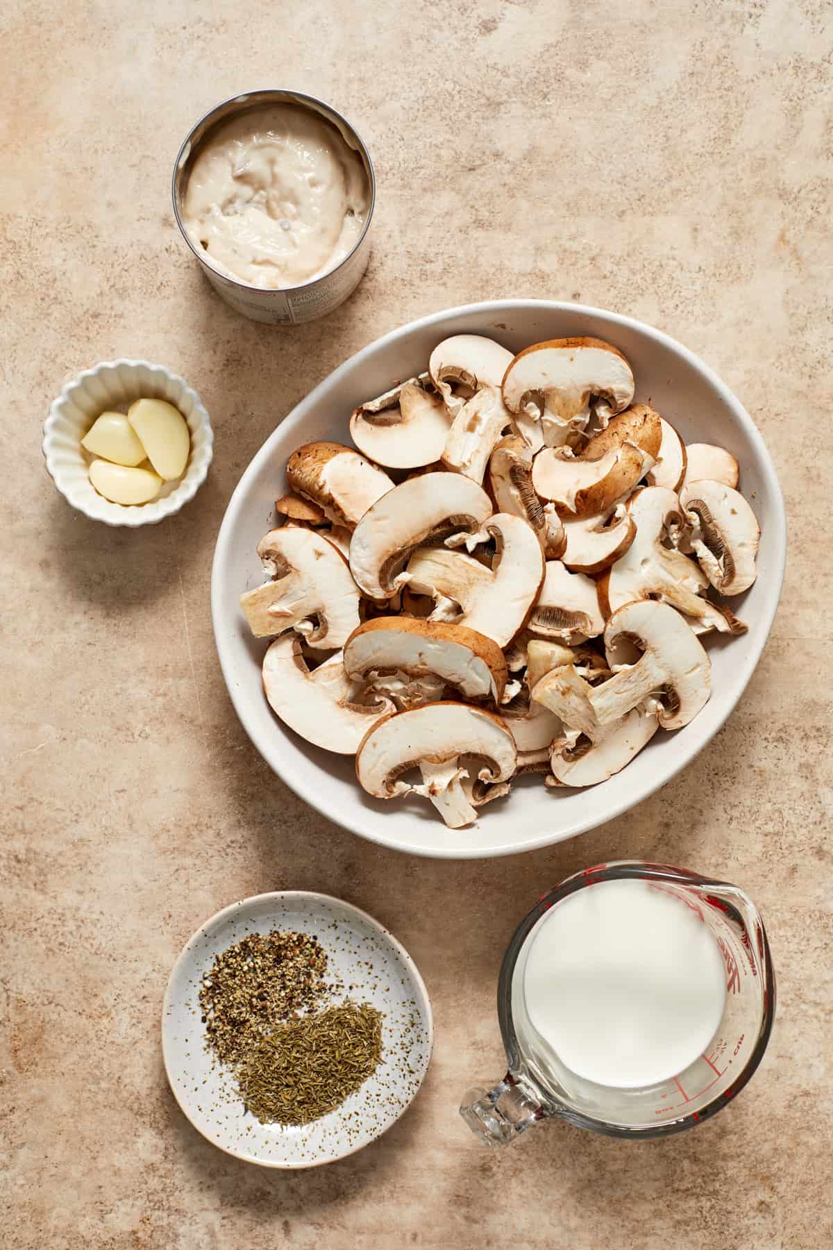 Ingredients to make creamy mushroom sauce on surface.