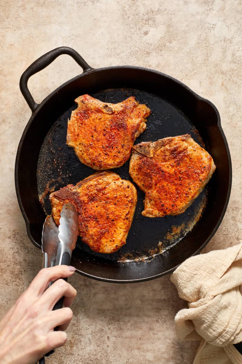 Browned pork chops in skillet.