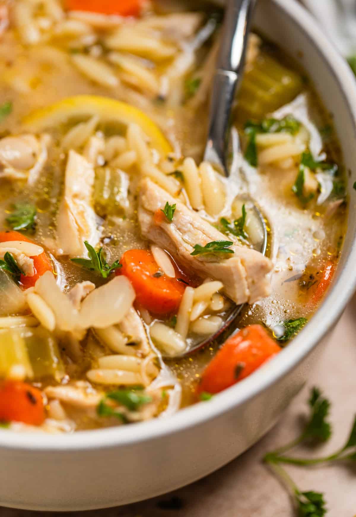 Spoonful of lemon chicken and orzo soup.