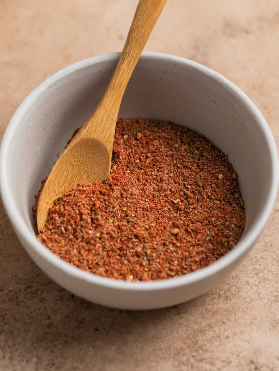 Dry rub in bowl with small wooden spoon.