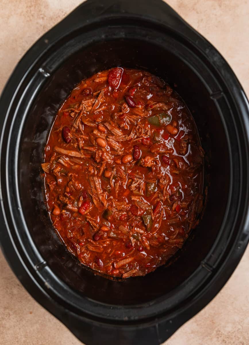 Shredded beef chili in crockpot after freshly shredded beef is added into the pot.